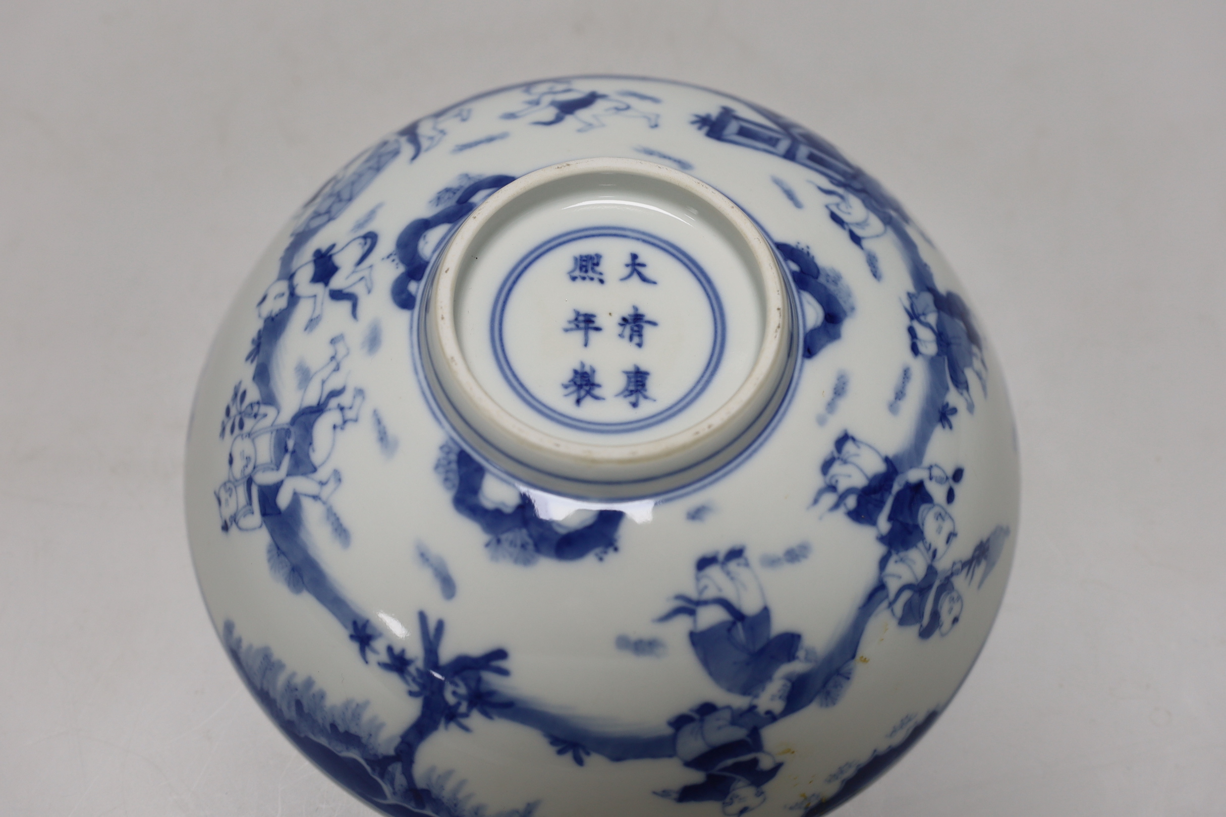 A Chinese blue and white ‘boys’ bowl and two blue and white flower plates, largest 24cm diameter